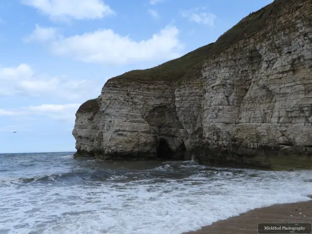 Surf breaks against the headland at Bempton Cliffs.