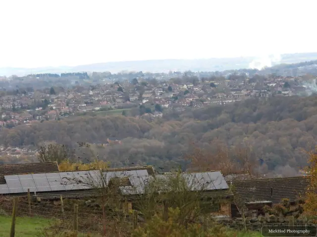 A wide view over the wooded countryside and rooftops from the common.