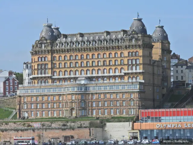 Scarborough's Grand Hotel rises above South Bay, with the promenade and seafront in the foreground.