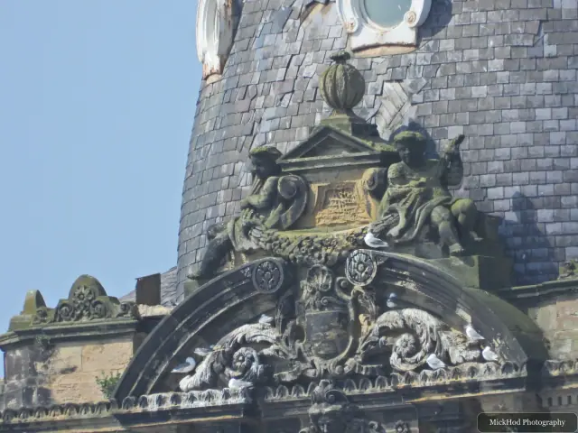 Decorative stone figures frame a curved slate-roofed section of Scarborough's Grand Hotel.